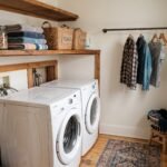 Small laundry room with stacked washer and dryer, wood shelf with baskets, and shirts air-drying on a slim rod