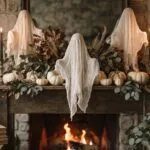 DIY Halloween decorations styled on a mantel with cheesecloth ghosts, black tapers in brass candlesticks and cream heirloom pumpkins