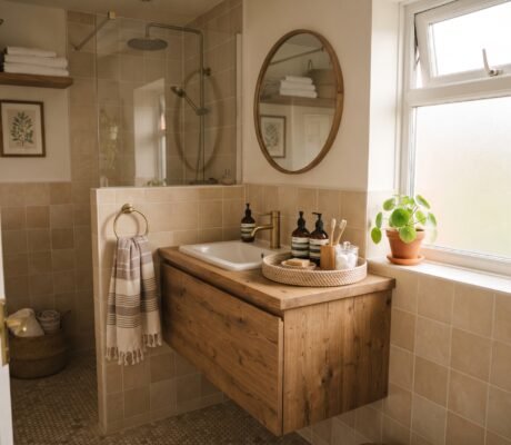 Small organized bathroom vanity with a woven tray, styled toiletries, and a potted plant